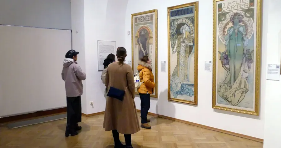 Επισκέπτες περιηγούνται σε αίθουσα γκαλερί με κορνιζαρισμένους πίνακες στους τοίχους — Ασφάλιση Έργων Τέχνης
